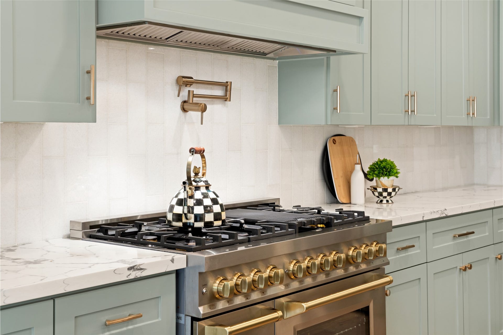 14 Lush Meadow Place, The Woodlands, TX 77381 A statement gas range, custom vent hood, and dramatic black pendant lights add just the right amount of personality.