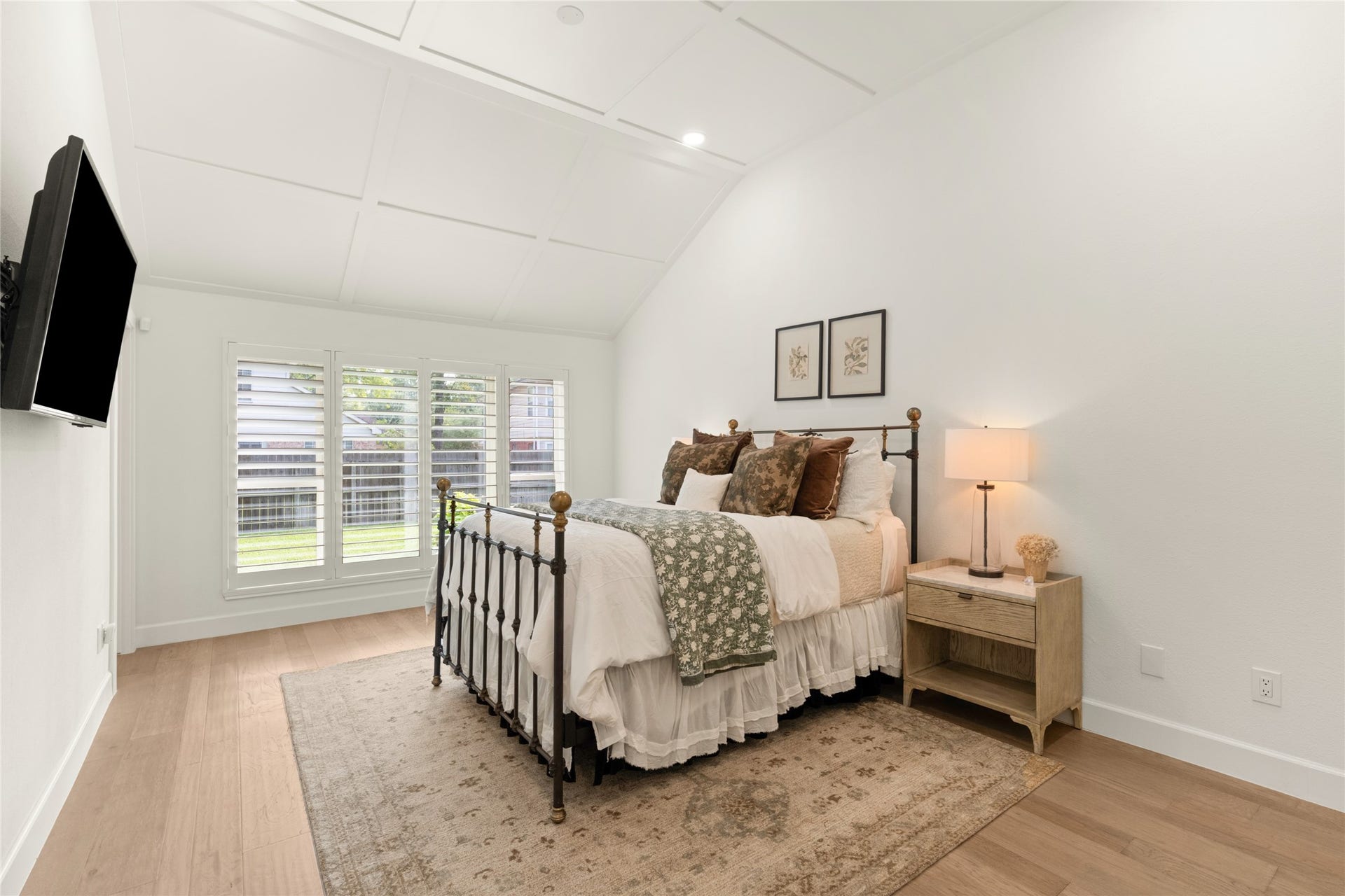 14 Lush Meadow Place, The Woodlands, TX 77381 The primary bedroom features a vaulted ceiling with elegant decorative trim, giving the room an architectural detail that immediately catches your eye.