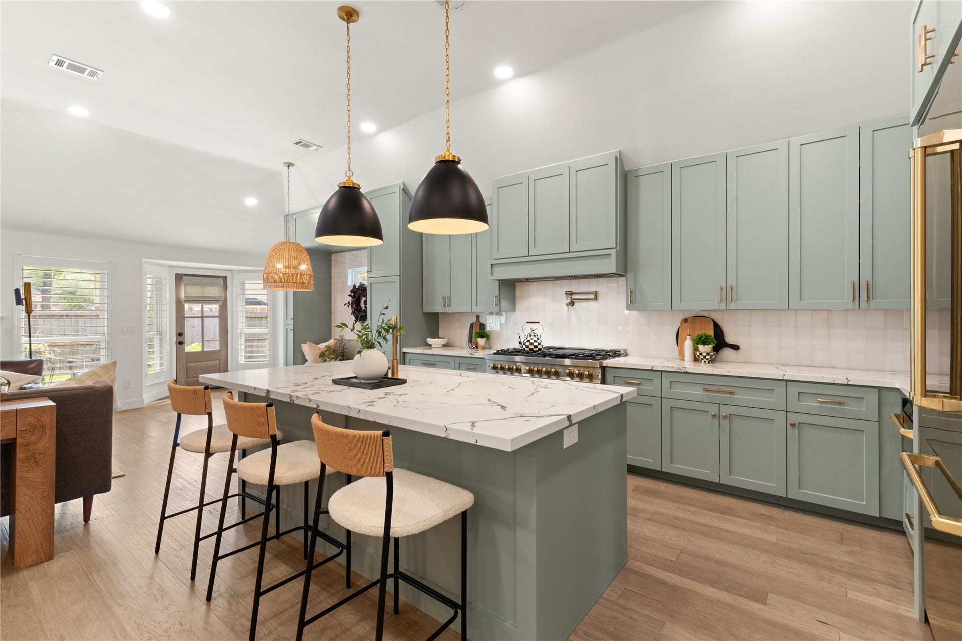 14 Lush Meadow Place, The Woodlands, TX 77381 Stunning sage-green cabinetry, gold accents, and a professional-style gas range create a kitchen full of character.