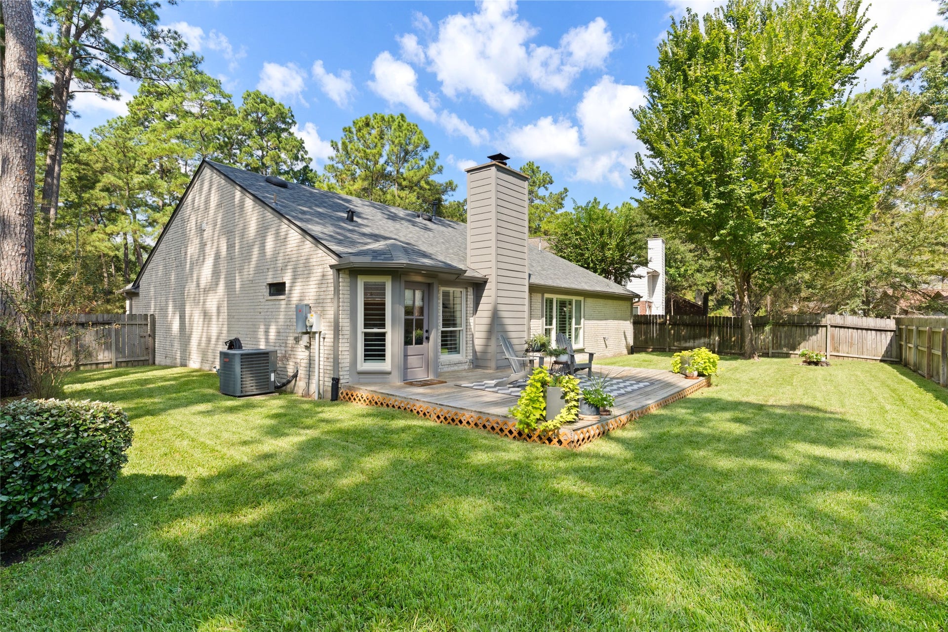 14 Lush Meadow Place, The Woodlands, TX 77381 The wooden deck extends from the house into the backyard, creating a natural place to gather.