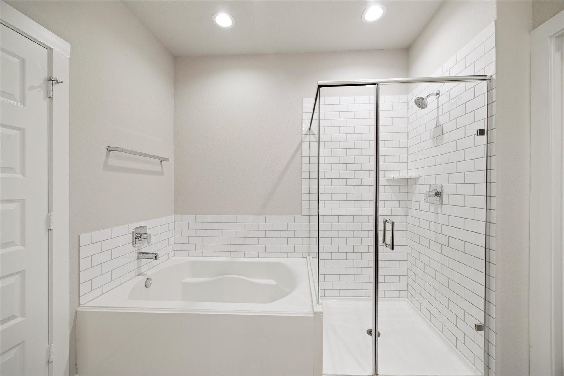 7503 Highland Chase Drive, Richmond, TX 77407 The bath includes a soaking tub paired with a glass enclosed shower, offering both relaxation and convenience. Subway tile and clear glass keep the design light and classic, while durable finishes support everyday living.