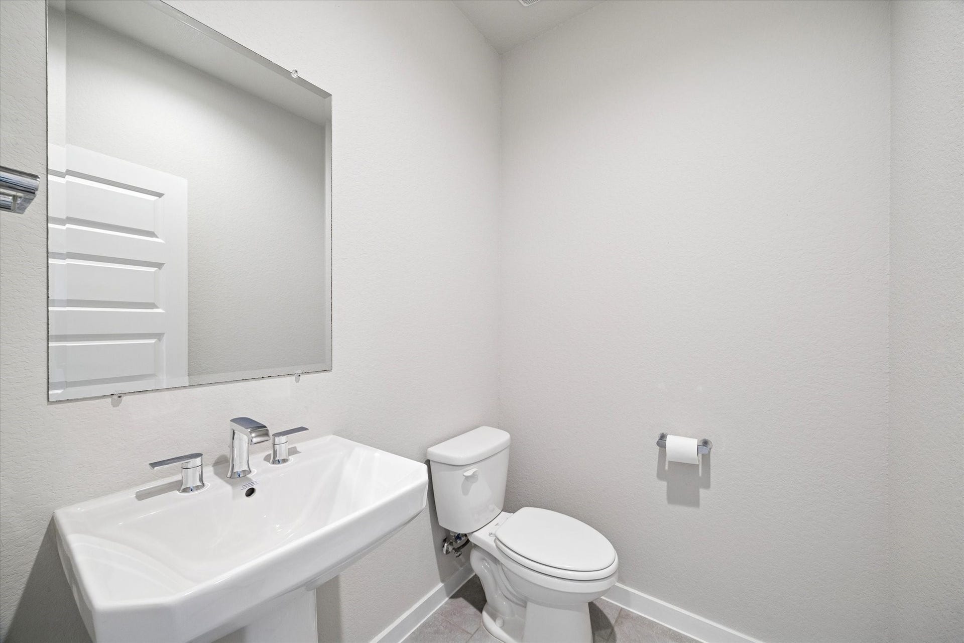 7503 Highland Chase Drive, Richmond, TX 77407 A clean, streamlined powder bath designed with simplicity and function in mind. The pedestal sink and large wall mirror keep the space feeling open and bright, while neutral finishes allow for easy personalization. Ideal for guests, this bath delivers practicality with a timeless, understated look.