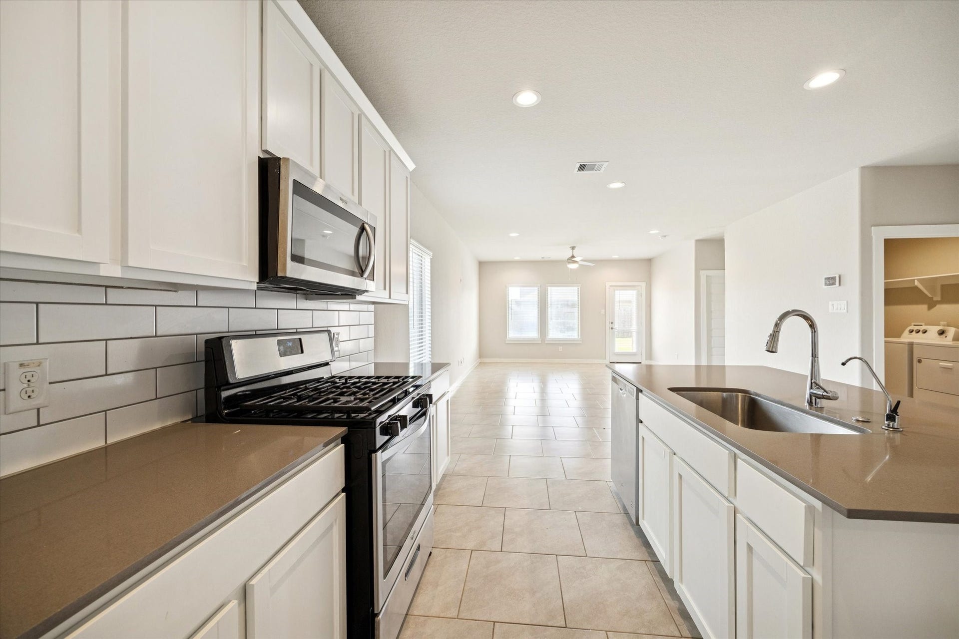 7503 Highland Chase Drive, Richmond, TX 77407 Gas range and built-in microwave pair with generous counter space, offering an efficient cooking layout framed by crisp white cabinetry.