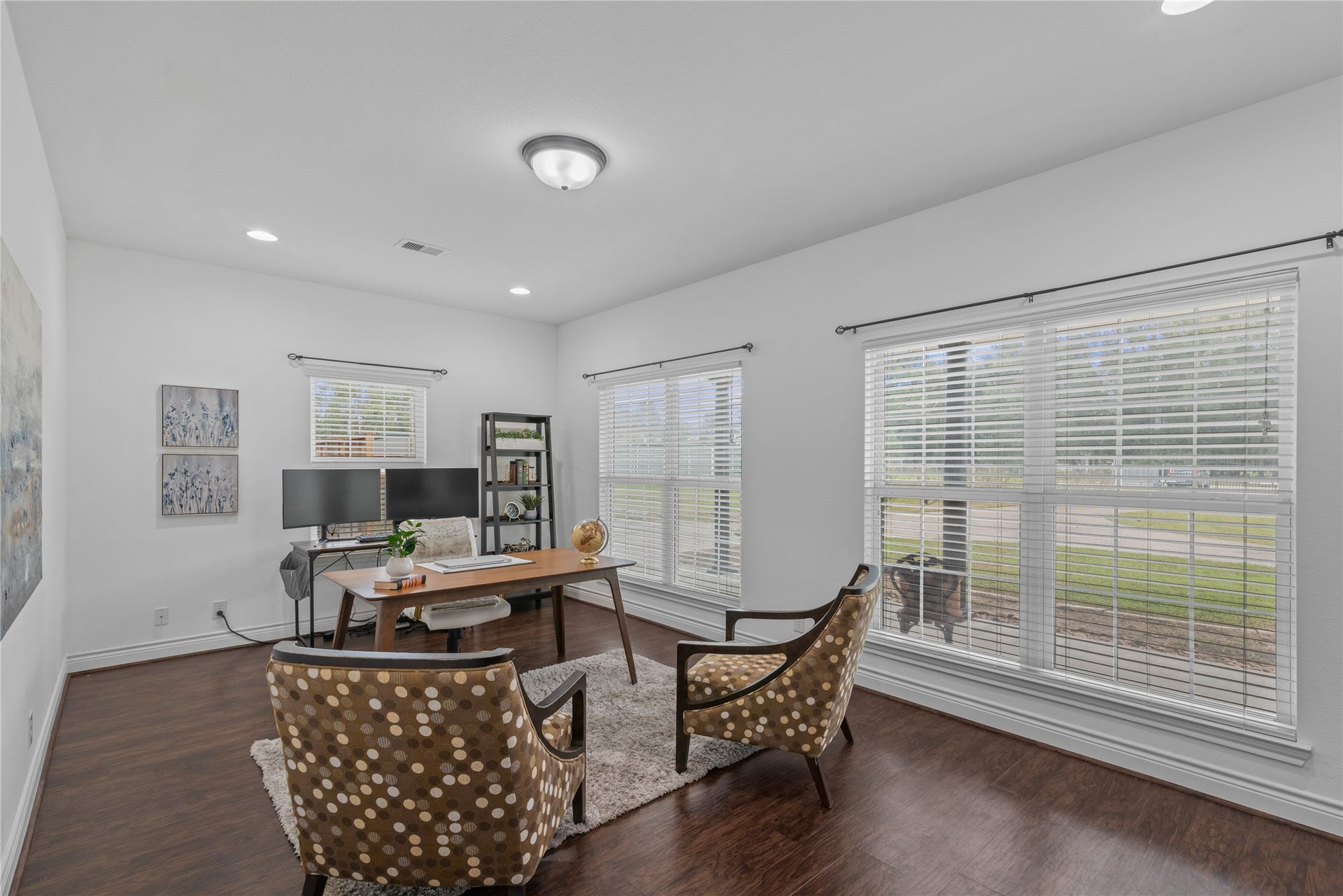 16144 Firetower Road, Conroe, TX 77306 Bright and spacious home office with large windows overlooking the front porch and lawn, offering ample room for a desk and additional seating.