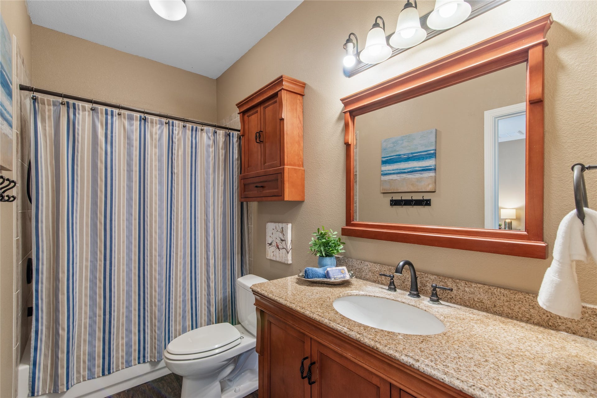 16144 Firetower Road, Conroe, TX 77306 Jack-and-Jill bathroom connecting two secondary bedrooms, featuring a tub/shower combination, a spacious vanity, and coordinating wood cabinetry for added storage.