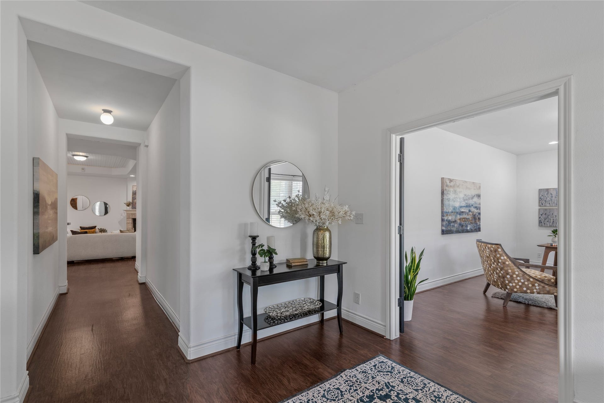 16144 Firetower Road, Conroe, TX 77306 Welcoming entry with high ceilings and rich wood-look flooring, offering access to the home office and a glimpse of the family room beyond.