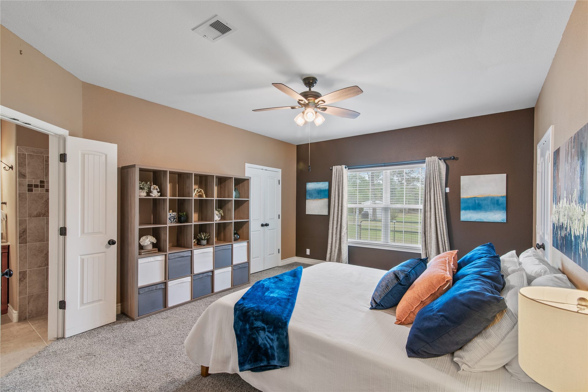 16144 Firetower Road, Conroe, TX 77306 Spacious primary bedroom featuring high ceilings, a large window, and a private en-suite bath, complemented by two walk-in closets for generous storage.
