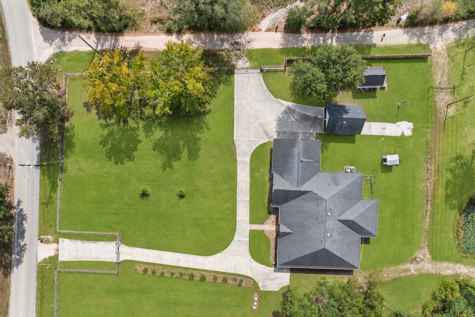 16144 Firetower Road, Conroe, TX 77306 Full driveway view highlights two separate entrances with automatic gates, providing convenient access and easy circulation throughout the property.