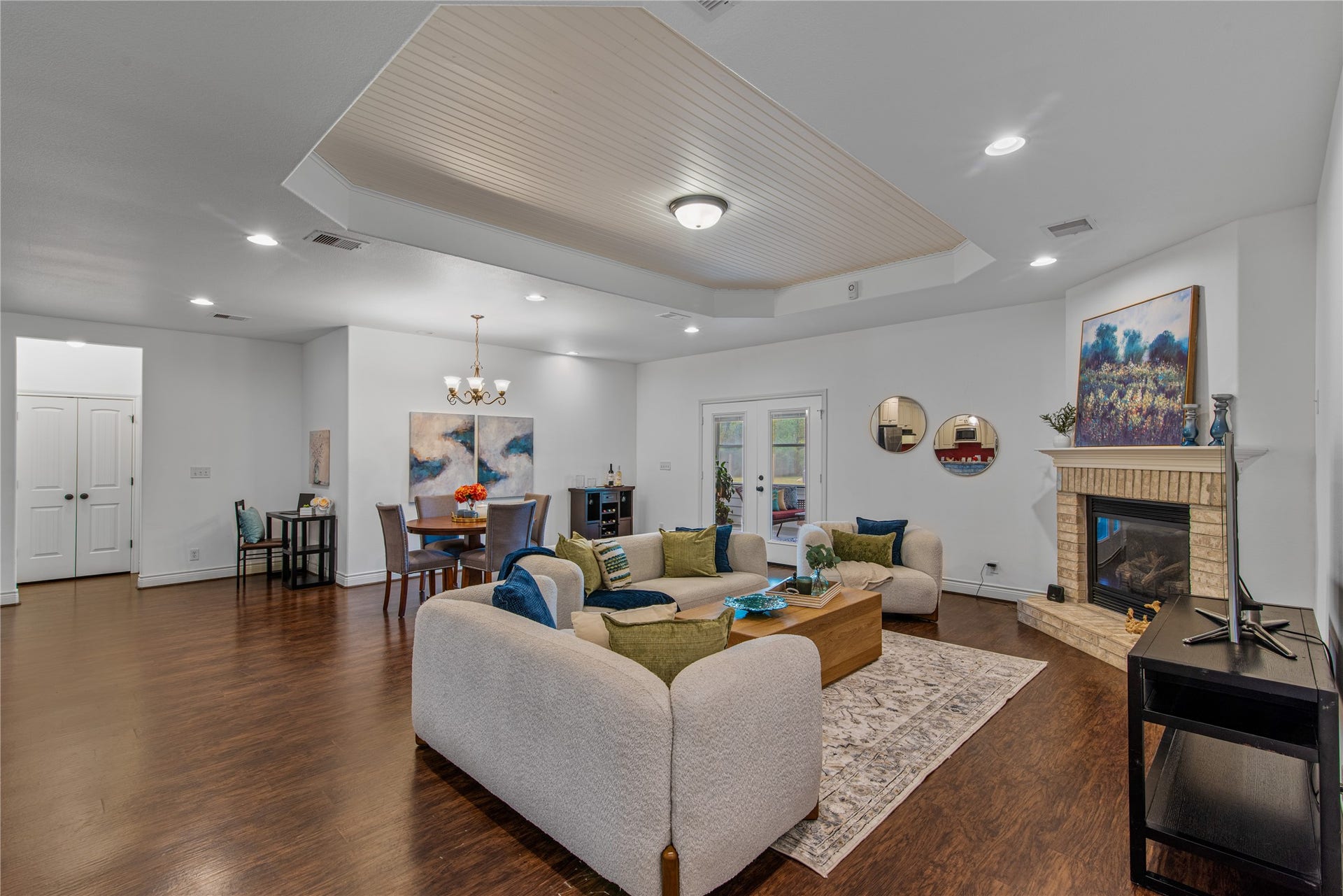 16144 Firetower Road, Conroe, TX 77306 Spacious family room featuring a distinctive tray ceiling with beadboard detailing and a brick fireplace, creating an inviting gathering space.