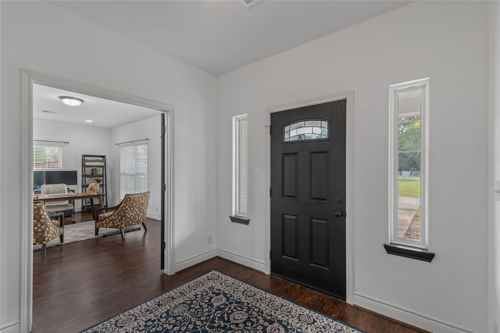 16144 Firetower Road, Conroe, TX 77306 A striking black front door with decorative glass and flanking sidelights brings character and natural light to the large entry.