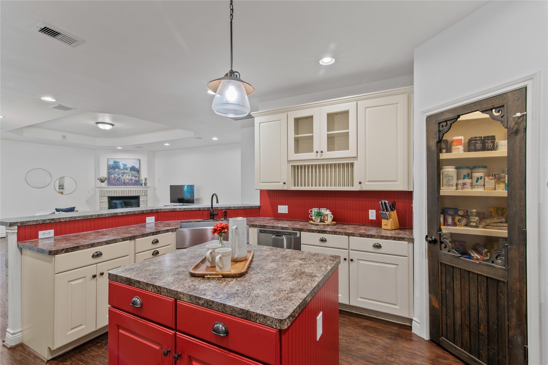 16144 Firetower Road, Conroe, TX 77306 A farmhouse-style sink, built-in plate rack, and decorative wood pantry door bring charm and practical touches to the kitchen.