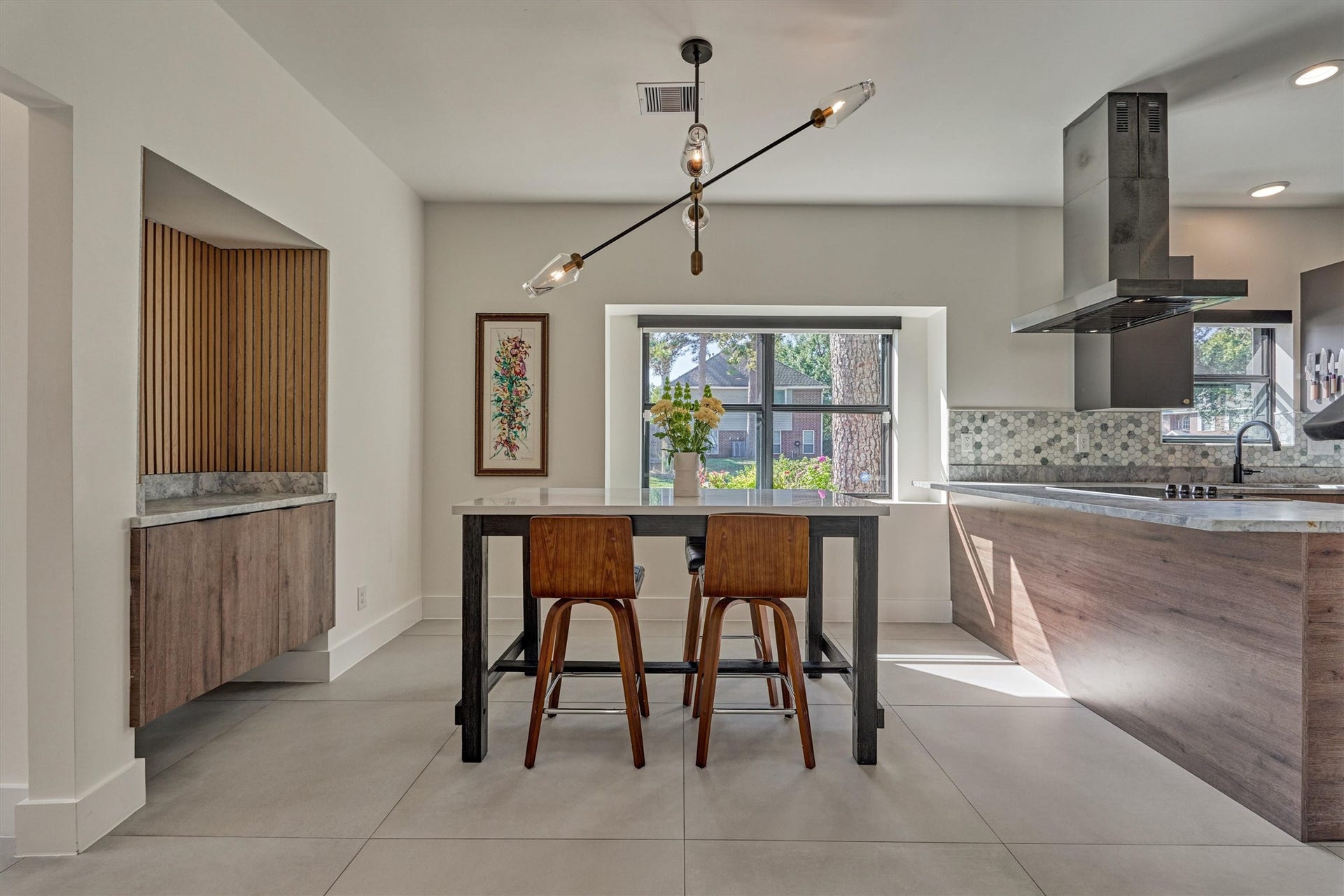 402 Susan Lane, Conroe, TX 77385 Sunny breakfast room offers statement chandelier, bonus floating cabinetry with paneled accents for additional storage, and adjacent bar area for added seating options if desired.