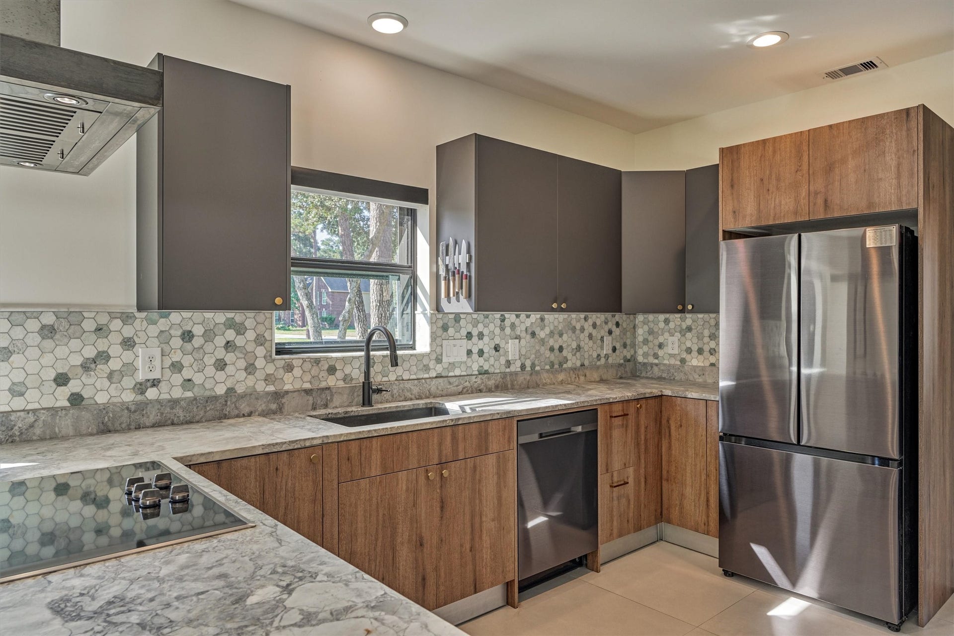 402 Susan Lane, Conroe, TX 77385 LED lighting throughout this home upgrades the space to complete the clean, modern aesthetic. Note the stainless appliance package and sleek cooktop.