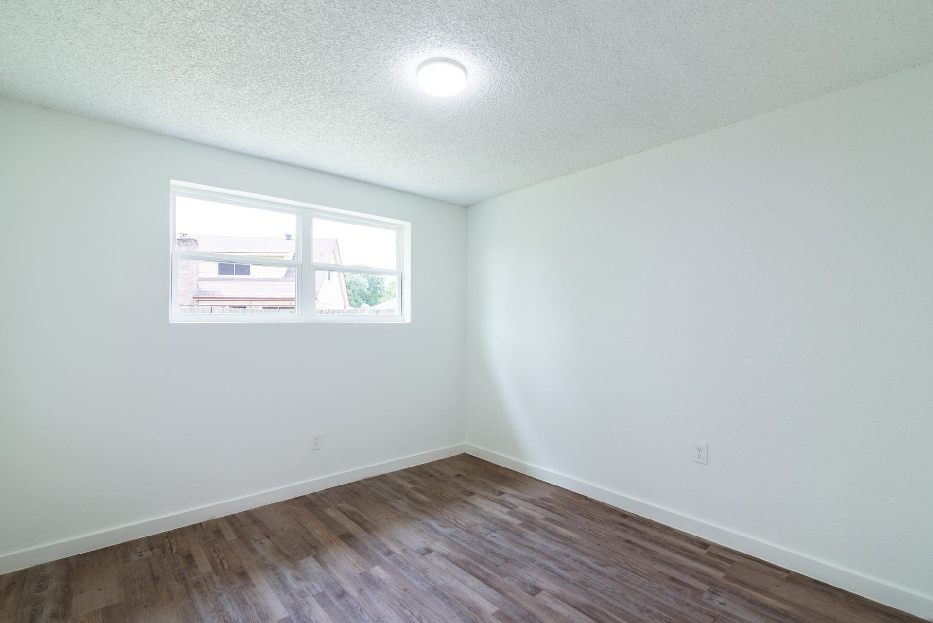 15910 Plagens Lane, Missouri City, TX 77489 Bright and airy room featuring a large window and sleek hardwood flooring, perfect for a cozy retreat or home office.