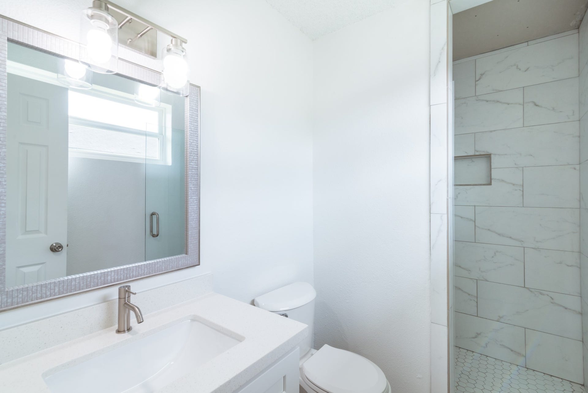 15910 Plagens Lane, Missouri City, TX 77489 Bright, modern bathroom featuring a sleek vanity with a stylish mirror, contemporary lighting, and a spacious tiled shower.