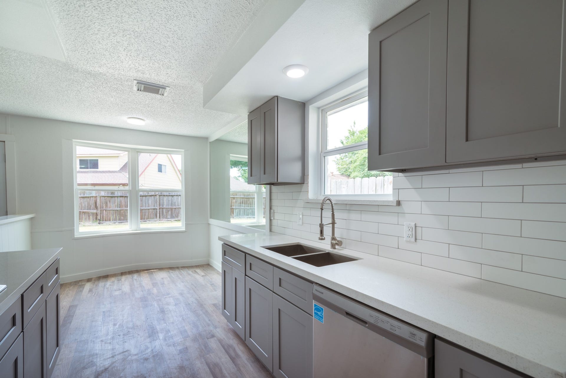 15910 Plagens Lane, Missouri City, TX 77489 Bright and airy kitchen with modern gray cabinetry, sleek countertops, and stylish subway tile backsplash.