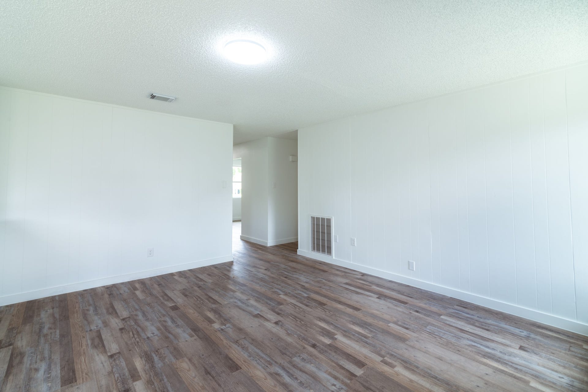 15910 Plagens Lane, Missouri City, TX 77489 Spacious living area with fresh white walls and warm wood flooring, offering a bright and inviting atmosphere.