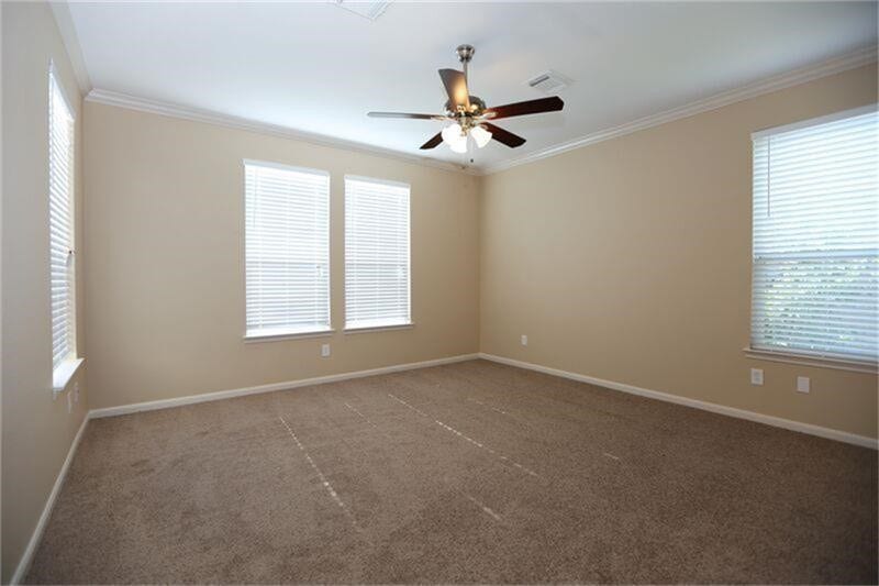 3126 Richland Spring Lane, Sugar Land, TX 77479 Spacious bedroom featuring large windows for natural light, neutral walls, and a ceiling fan for comfort.