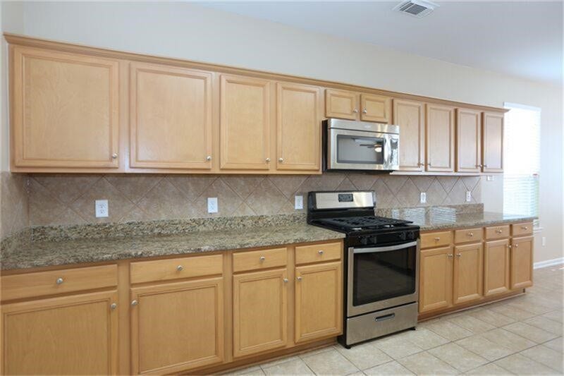 3126 Richland Spring Lane, Sugar Land, TX 77479 KItchen with Gas Cooking Range & Microwave