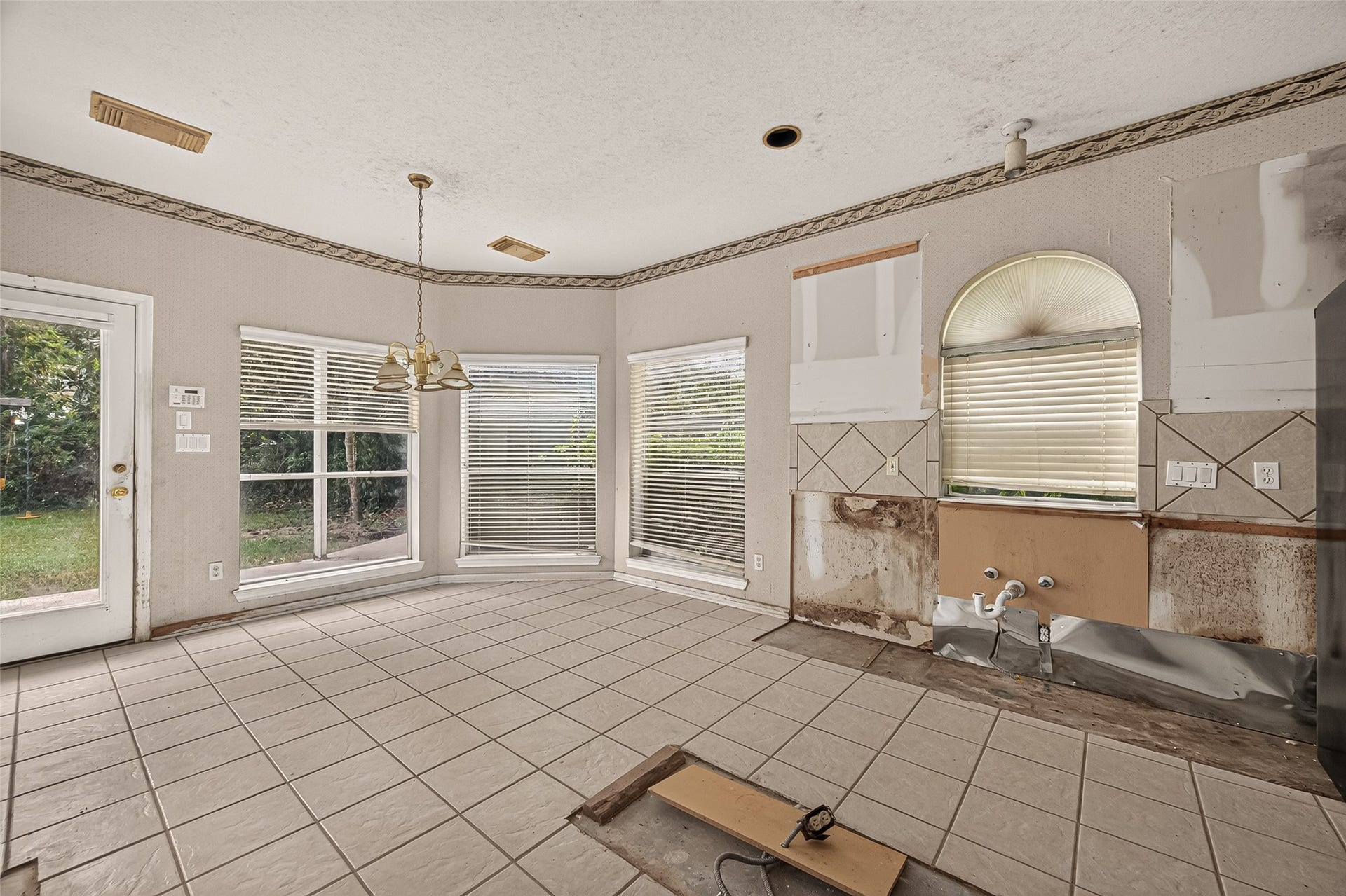2602 Pinebend Drive, Pearland, TX 77584 Tiled kitchen with sunny breakfast area overlooks back lawn. Kitchen cabinetry, island, and fixtures were removed during unfinished remodling.