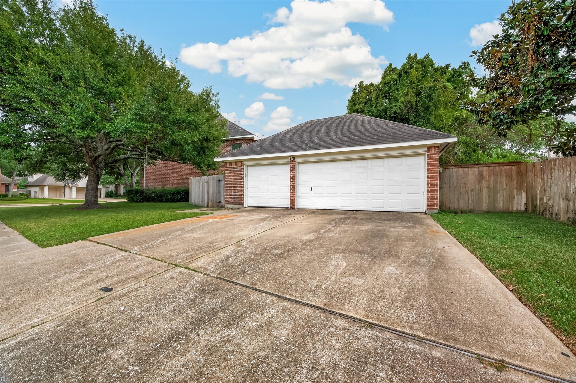 2602 Pinebend Drive, Pearland, TX 77584 Detached 3-car garage (with remote openers) sits at the rear corner of the property, with driveway spacing for additional parking and access to the wraparound sidewalk.