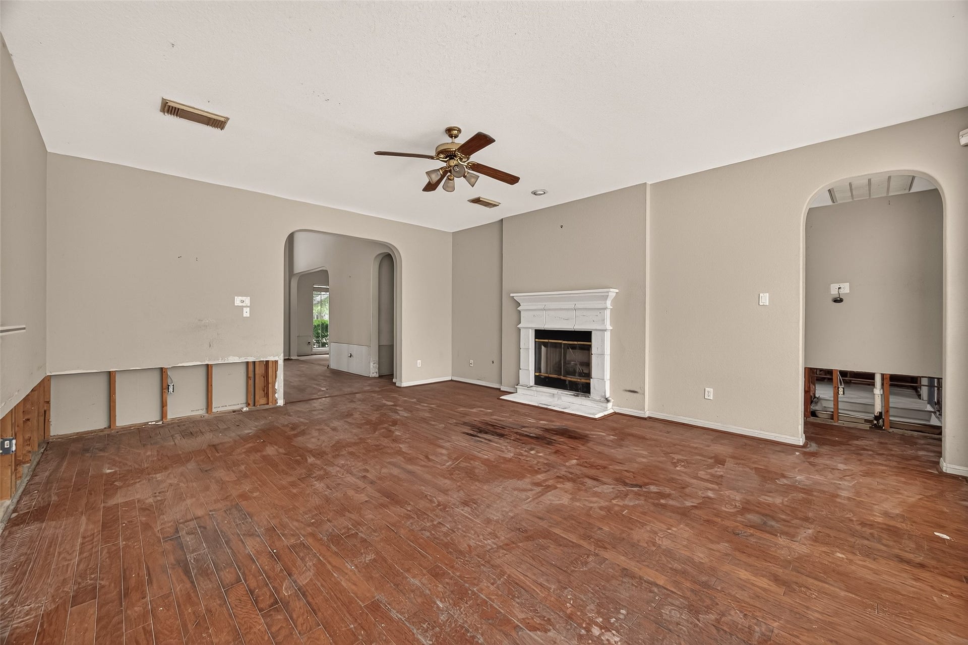 2602 Pinebend Drive, Pearland, TX 77584 This inviting family room featuring a gas log fireplace with stone hearth for cozy winter days. The arched passageways and gorgeous accenting hardwood floors highlight the flow of this home's open floorplan.