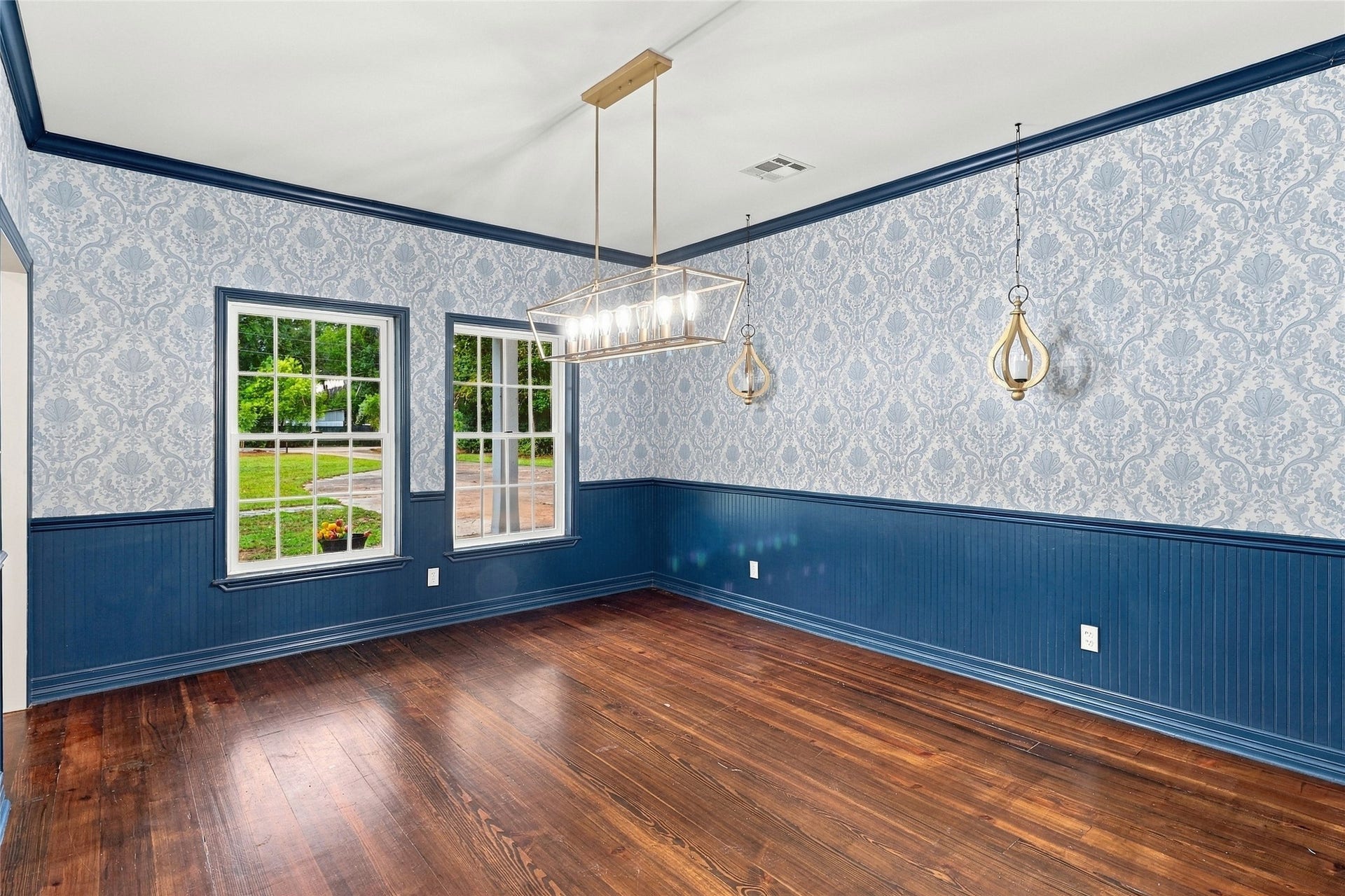 8714 Holly Hills Drive, Tomball, TX 77375 This elegant dining room features beautiful wainscoting and tasteful wallpaper, illuminated by abundant natural light.