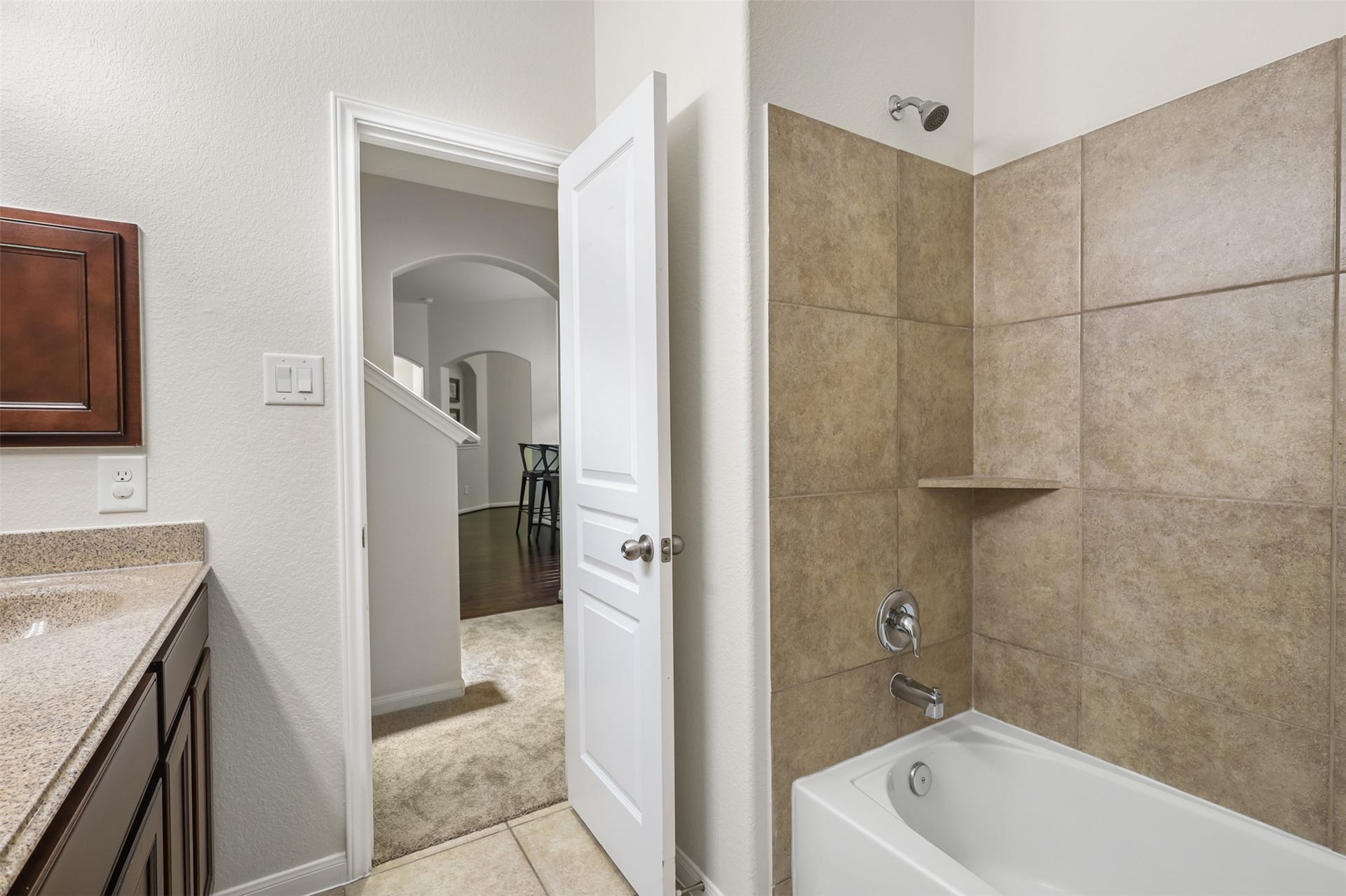 9731 Carina Forest Court, Humble, TX 77396 The secondary bathroom is designed with everyday convenience in mind, offering a spacious vanity with ample cabinetry and generous counter space. The large mirror and neutral finishes keep the room bright, clean, and easy to use.