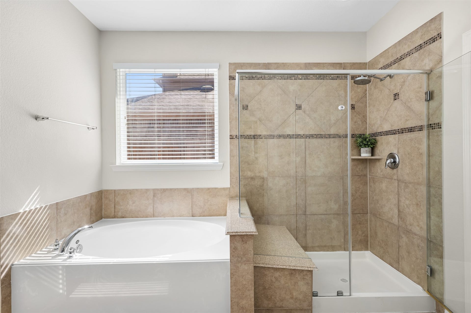 9731 Carina Forest Court, Humble, TX 77396 The separate walk-in shower adds another layer of convenience to the primary bath, featuring a glass enclosure, built-in corner shelf, and decorative tile accents. Positioned alongside the soaking tub, the layout provides both everyday functionality and a relaxing place to unwind.