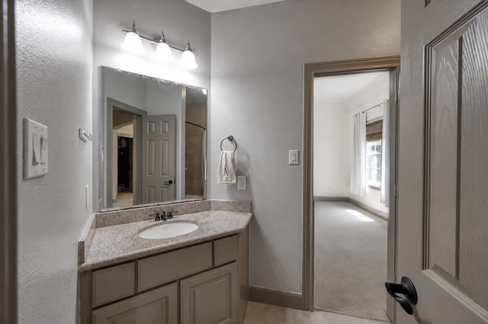 Upstairs bath with direct bedroom entry, granite vanity top, neutral tile floor, and tub/shower combo.