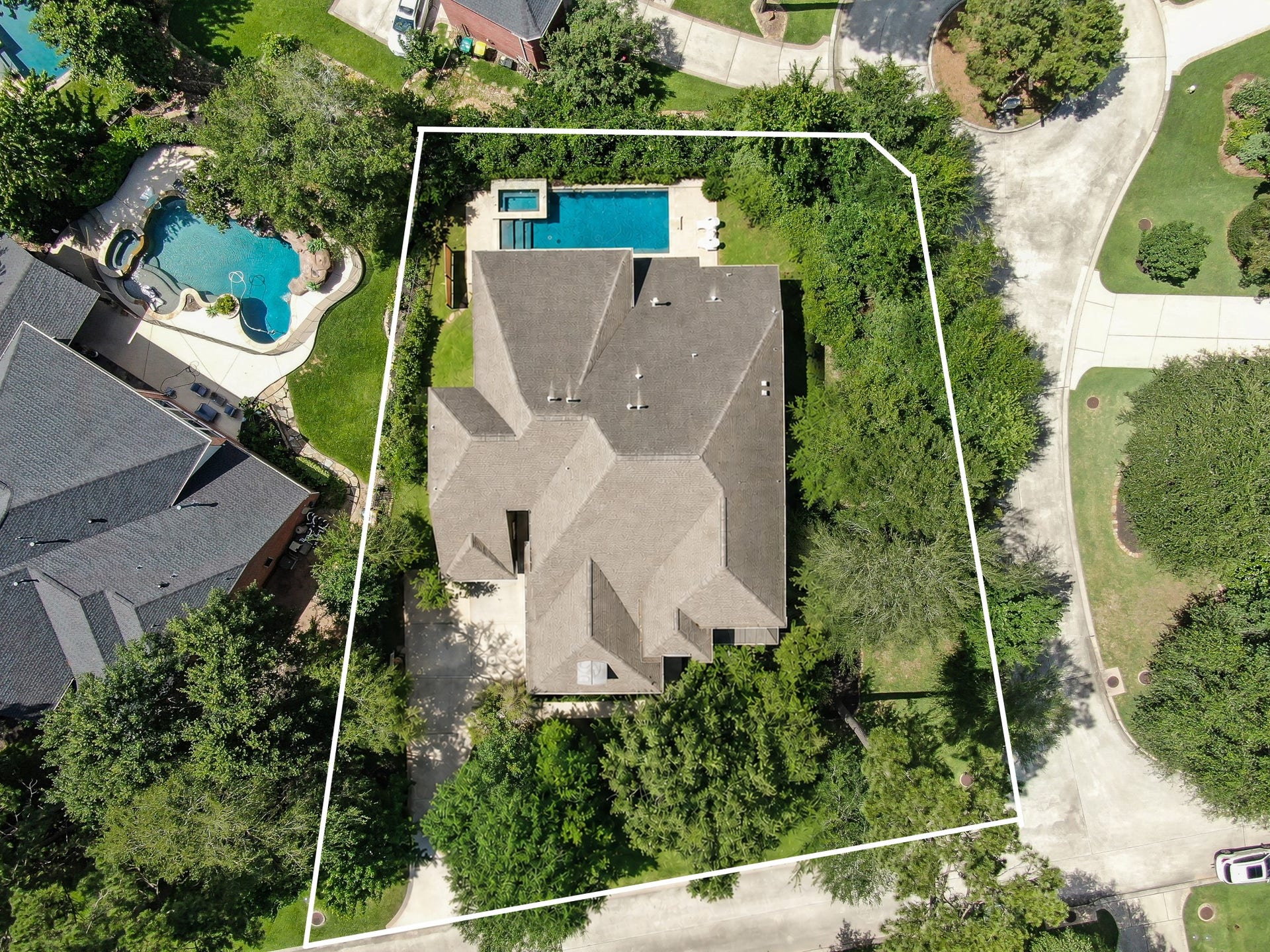 Aerial lot view with white boundary lines showing the corner greenbelt lot and pool placement.