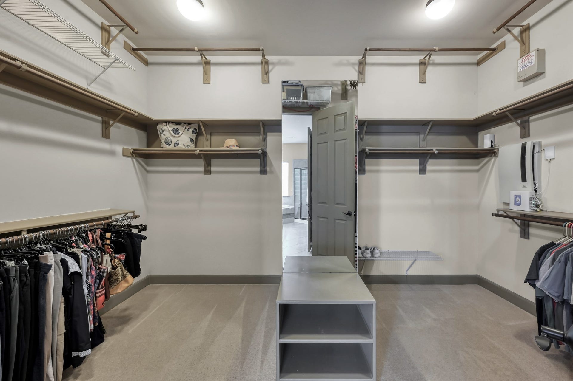 Primary walk-in closet with built-in shelving, plenty of hanging space, additional storage, and a center storage island.