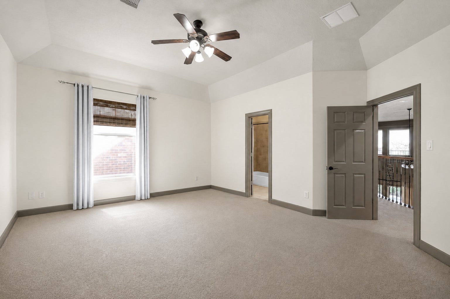 Upstairs Bedroom with Semi-Private Bath

Spacious upstairs bedroom featuring direct, private interior access to a full bath (also accessible from the hallway). Soaring vaulted ceiling, central ceiling fan, fresh neutral paint, and plush carpeting create a bright and comfortable retreat.