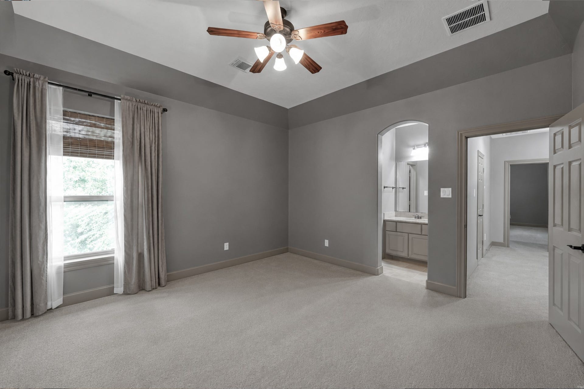 Third upstairs bedroom highlighting high vaulted ceilings, soft neutral carpet, and seamless access to its dedicated vanity space in the connected Jack-and-Jill bath setup.