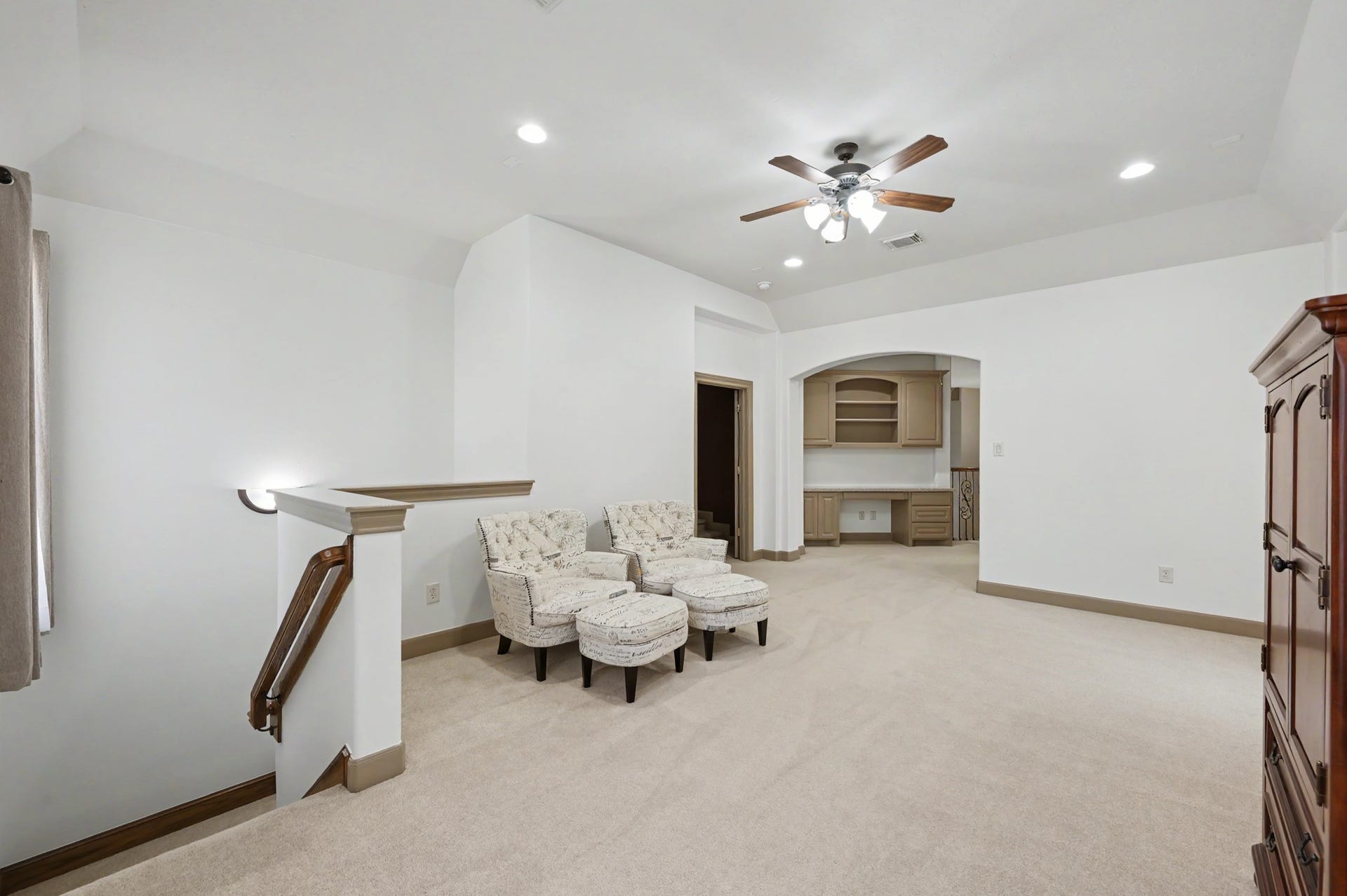 Upstairs game room or sitting area with carpet, ceiling fan, and large windows