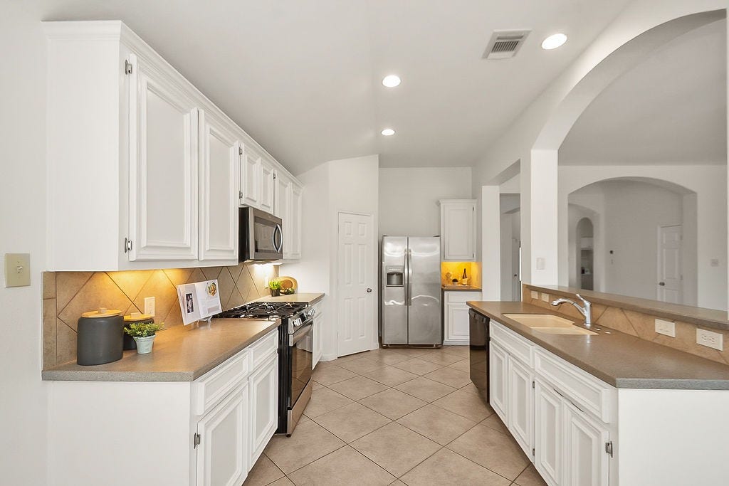 14903 Meridian Park Lane, Humble, TX 77396 The kitchen offers Corian countertops, tile backsplash, under cabinet lighting, and nice size pantry, and a Stainless Steel refrigerator.