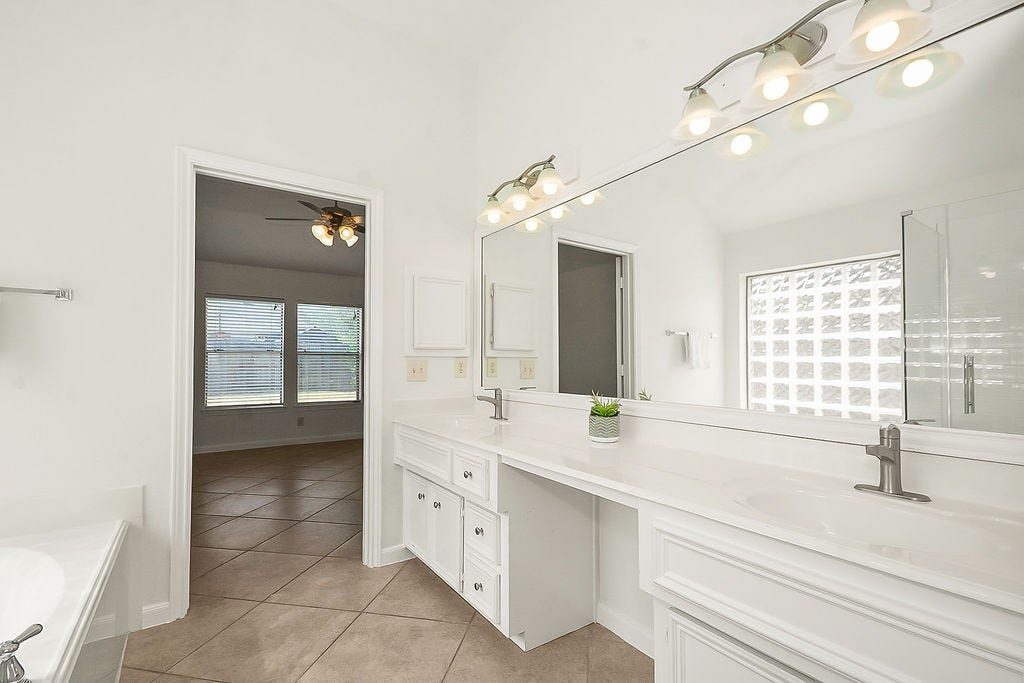 14903 Meridian Park Lane, Humble, TX 77396 The primary bath offers double sinks and a vanity, a soaking tub and separate shower and water closet with a brand new toilet.