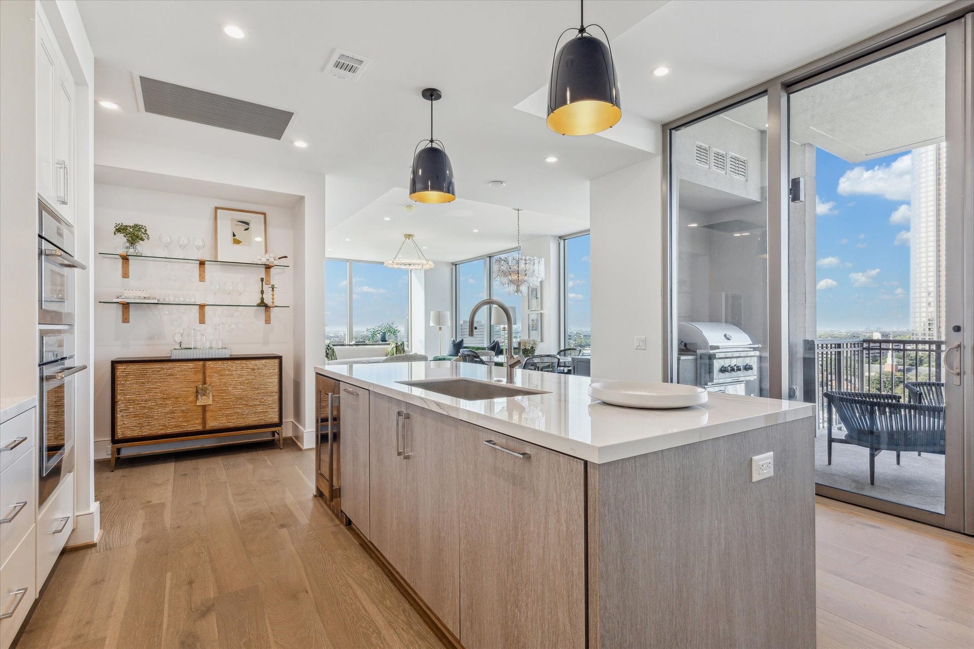 5656 San Felipe Street, #1005, Houston, TX 77056 Another kitchen perspective with center island and sliding door leading to the outdoor terrace. Photos are of a similar unit with the same floor plan.