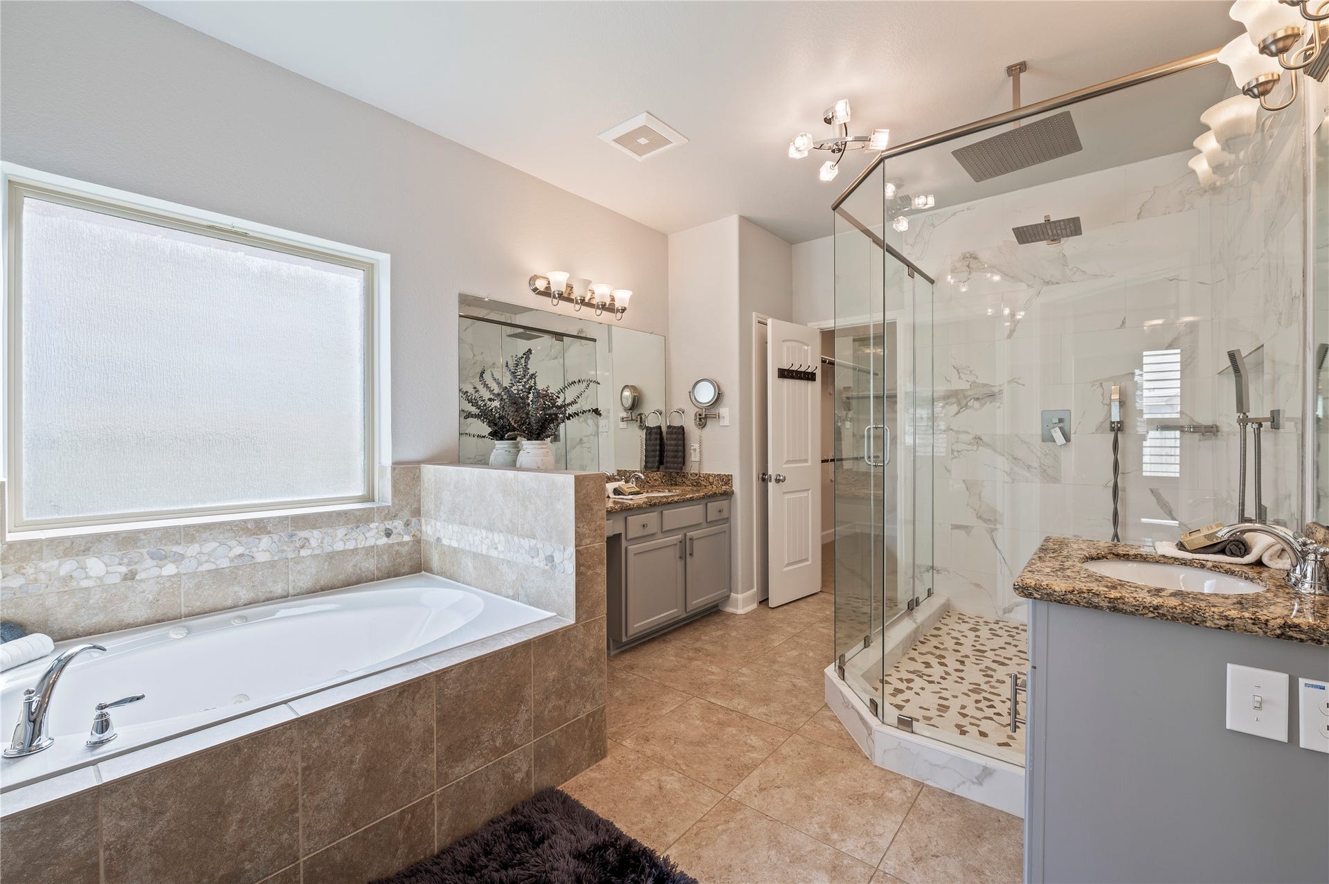 2322 Ashley Falls Lane, League City, TX 77573 Primary bathroom featuring a jetted soaking tub, updated shower, and dual vanities. Ceramic tile and grout recently professional cleaned upon seller's move out.