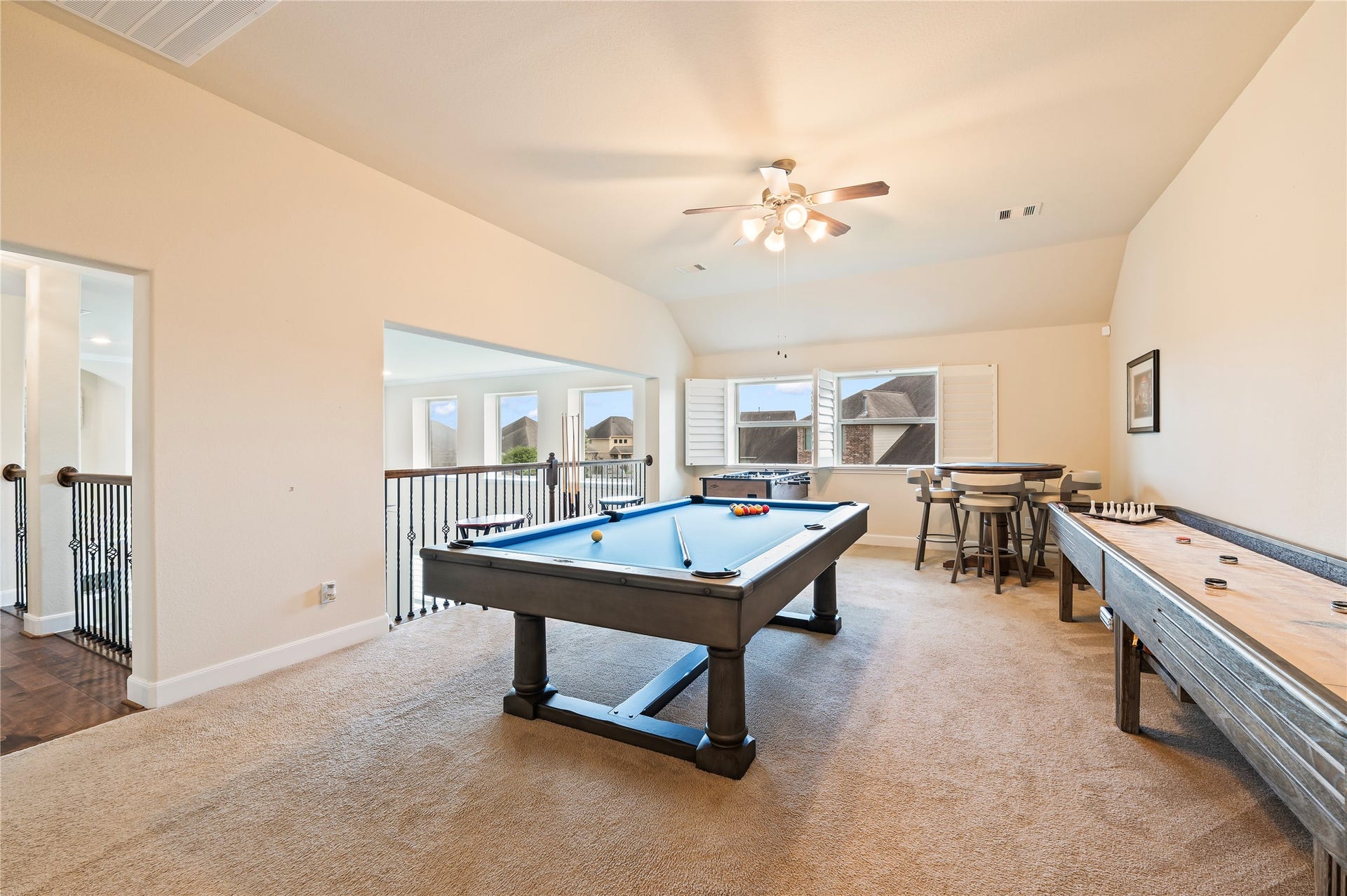 2322 Ashley Falls Lane, League City, TX 77573 Large gameroom accented by wrought iron spinals overlooking the family room; plantation shutters and neutral paint tones.