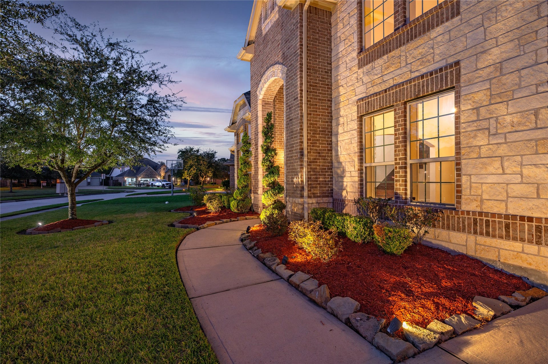 2322 Ashley Falls Lane, League City, TX 77573 Elevation B features professionally maintained lawn, extensive landscaping lighting, exterior stone accent and 2-story covered front porch.