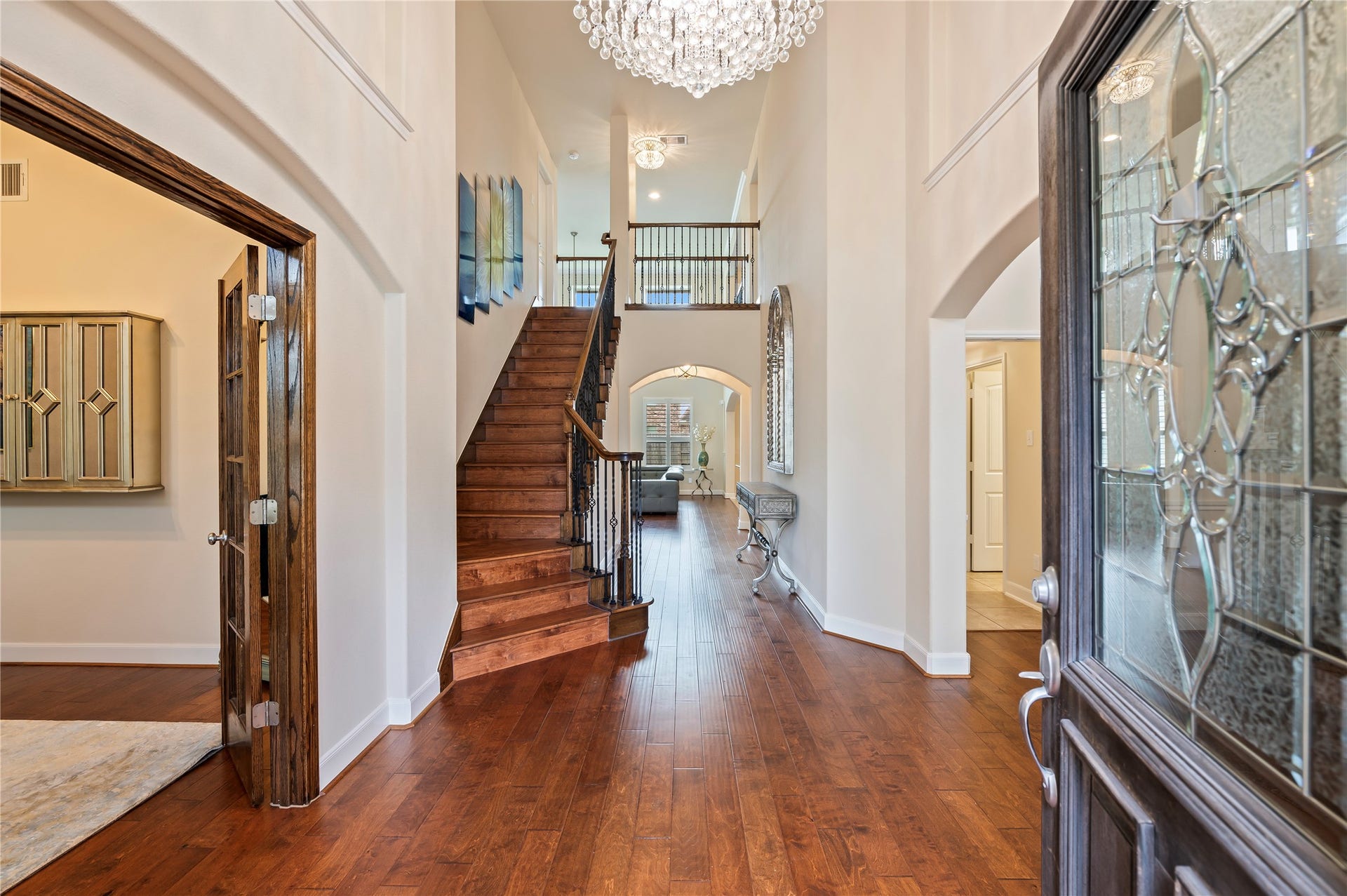 2322 Ashley Falls Lane, League City, TX 77573 Inviting entrance features soaring ceilings, custom chandelier and hardwood floors including the staircase with wrought iron railing and catwalk.
