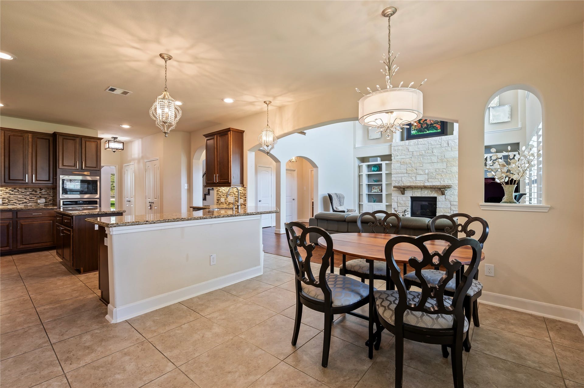 2322 Ashley Falls Lane, League City, TX 77573 Detailed view of the open concept kitchen, breakfast and family room with custom light fixtures and plantation shutters.