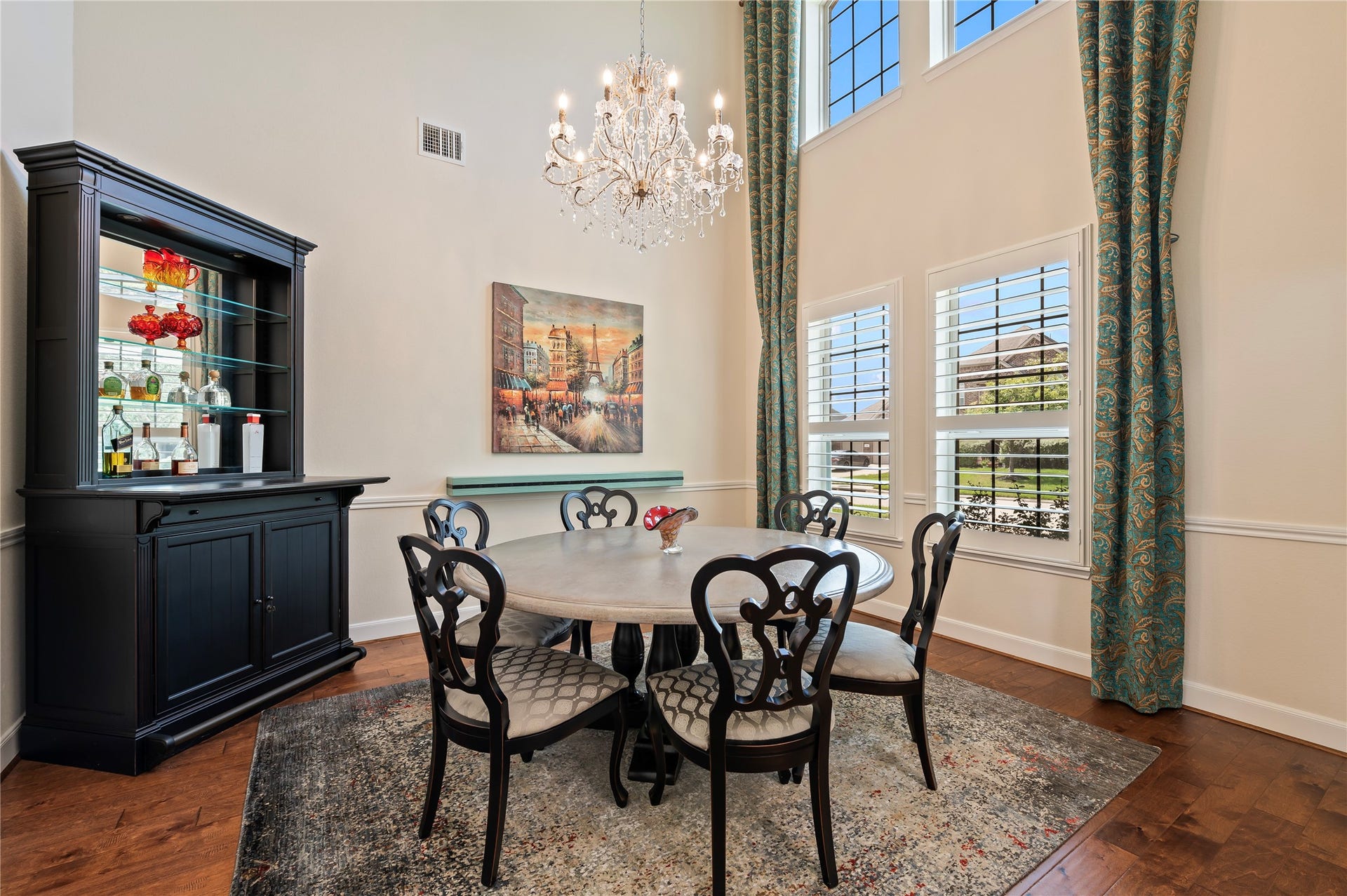 2322 Ashley Falls Lane, League City, TX 77573 Elegant two-story formal dining room features custom chandelier, hardwood flooring, chair-rail molding and plantation shutters.