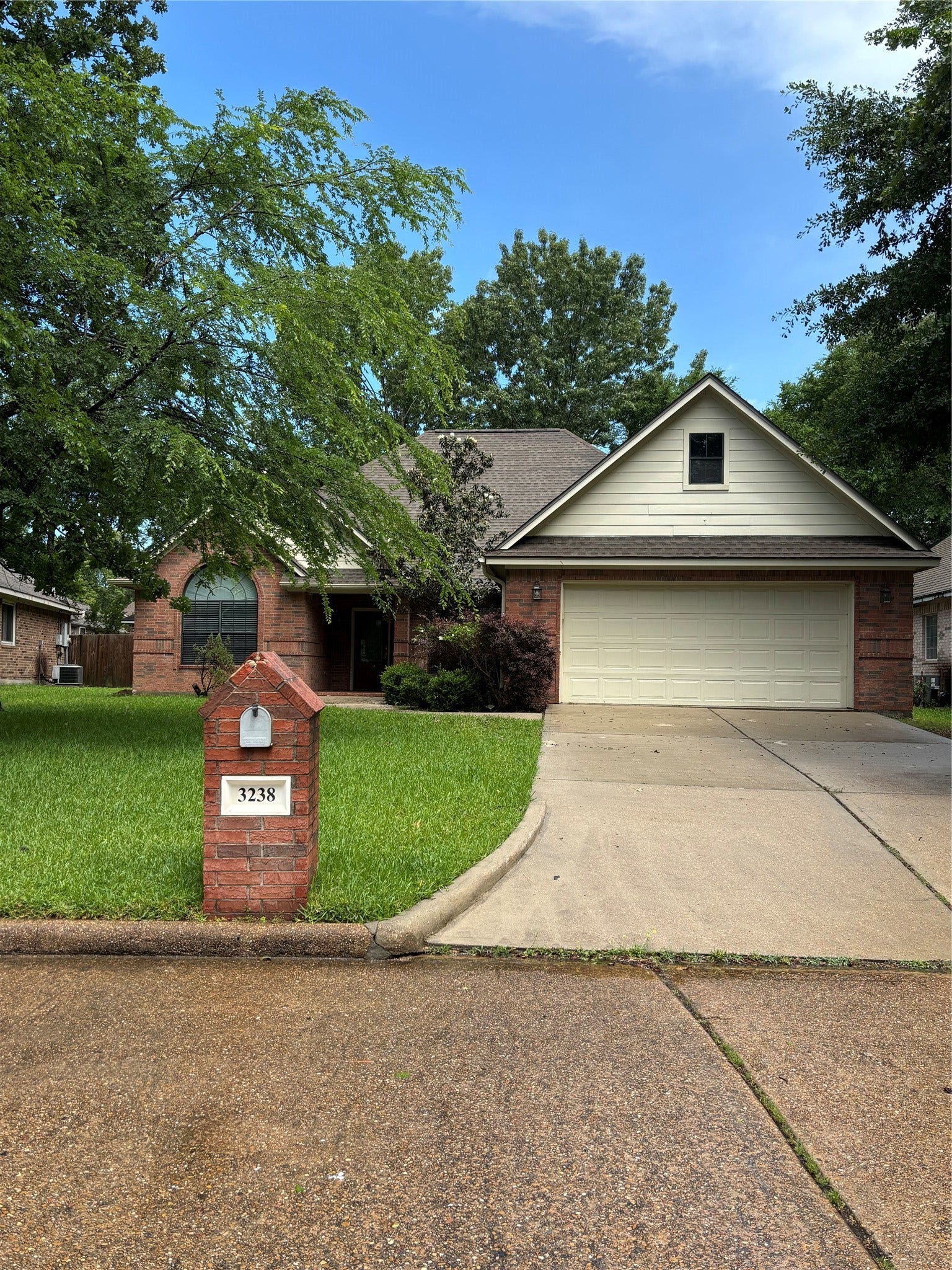 3238 Glenforest Drive, Montgomery, TX 77356 Charming single-story brick home with a two-car garage, lush green lawn, and mature trees. The driveway leads to a welcoming entrance, creating excellent curb appeal.