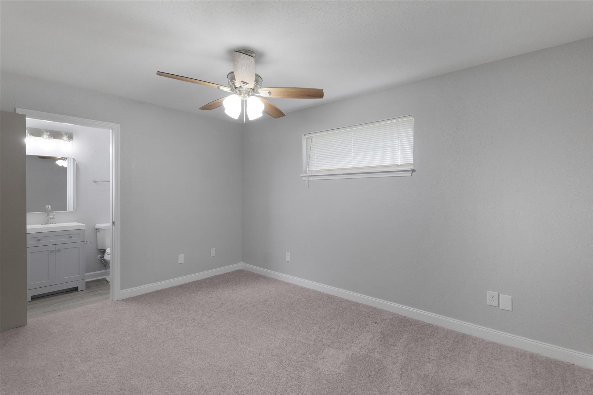 9827 Shive Drive, Houston, TX 77078 The primary bedroom offers a ceiling fan, neutral colors, and convenient access to its adjoining bathroom.