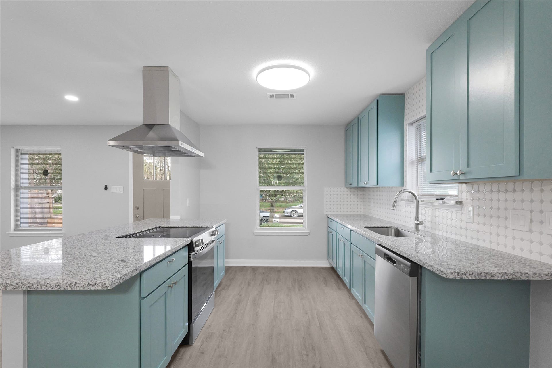9827 Shive Drive, Houston, TX 77078 Colorful cabinetry, stainless steel appliances, and a tile backsplash give this updated kitchen its standout style.