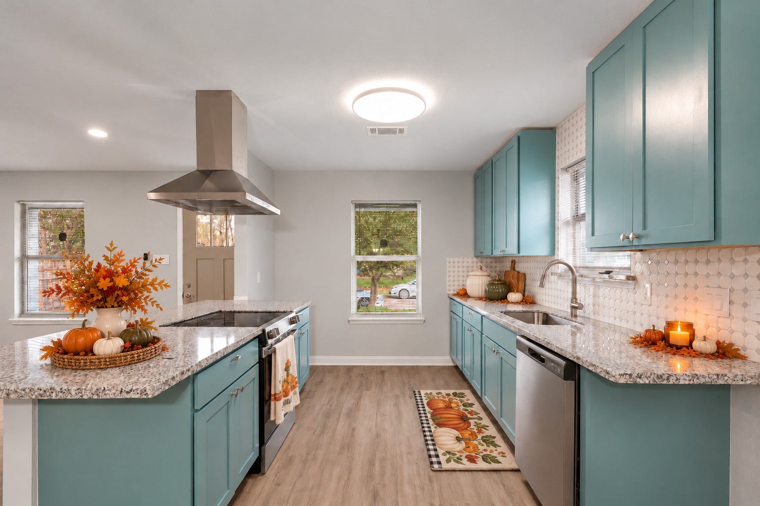 9827 Shive Drive, Houston, TX 77078 Updated kitchen featuring colorful cabinetry, stainless steel appliances, a tile backsplash, and an island with a range and vent hood. Digitally staged.