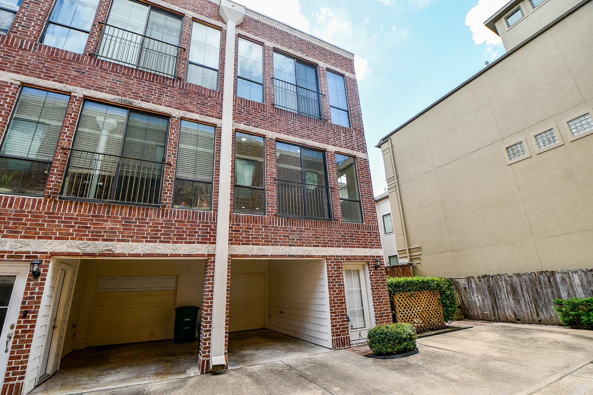 118 McGowen Street, #K, Houston, TX 77006 Beautiful brick exterior with one car garage plus an additional car covered porch area next the community common area.