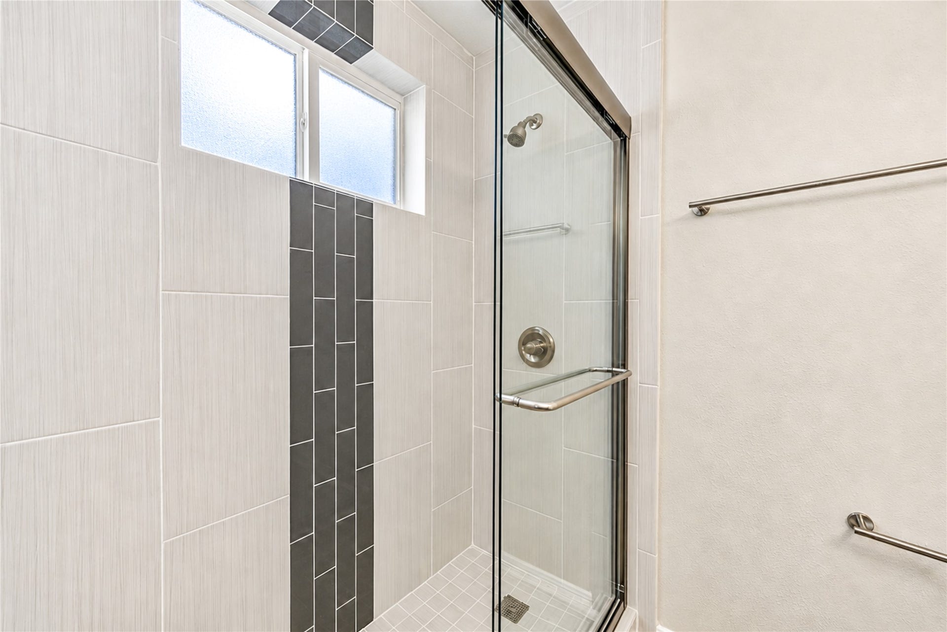 15106 Cypress Green Drive, Cypress, TX 77429 Redesigned primary shower with large-format porcelain tile, glass mosaic accent and new glass enclosure.